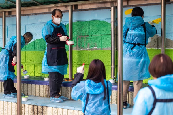 한국우편사업진흥원 임직원들이 9일 용두초등학교에서 벽화그리기 봉사활동을 하고 있다.(사진=한국우편사업진흥원 제공)