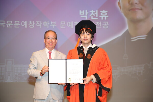 윤재웅 총장에게 동국대 명예졸업장을 수여받는 토니상 6관왕 수상의 박천휴 작가. (사진=동국대 홍보실 제공)